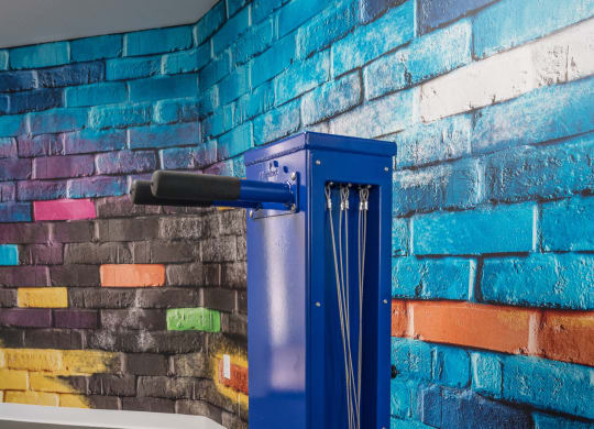 a blue metal elevator in front of a brick wall