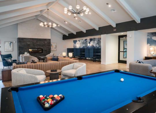 a community room with a pool table and couches
