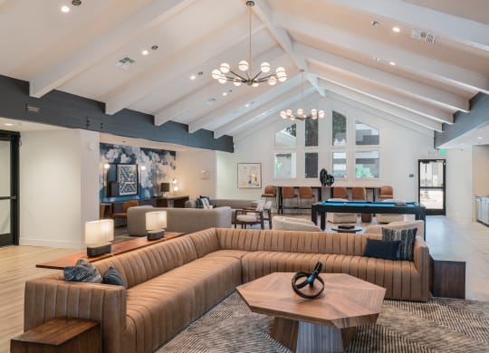 a clubhouse with couches and tables and a pool table