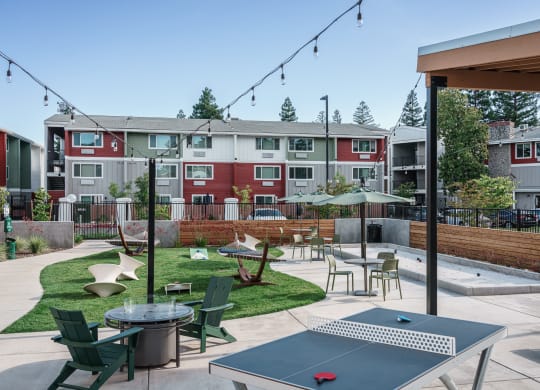 an outdoor patio with tables and chairs and an apartment building in the background