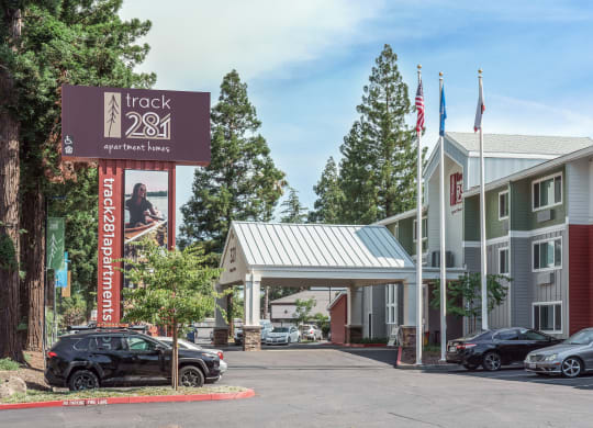 a hotel with a sign and cars parked in front of it