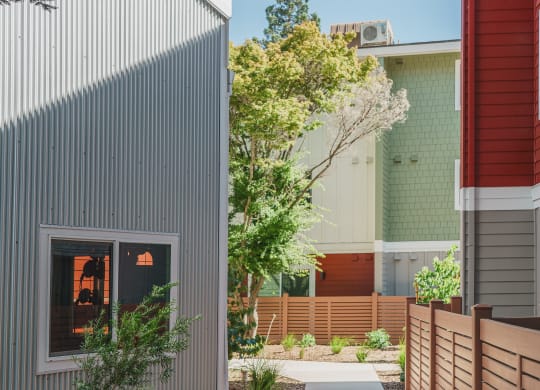 a walkway between two buildings with a fence