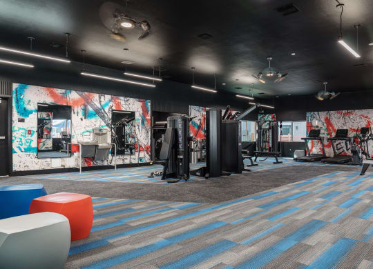 a fitness room with a mural of graffiti on the wall and exercise equipment
