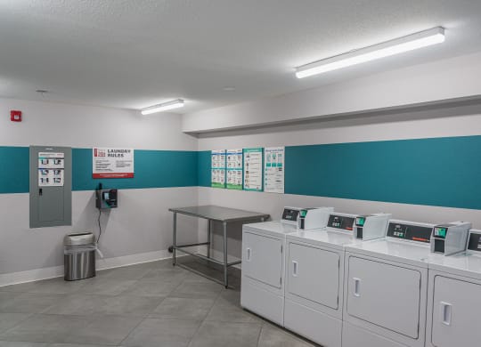 a laundry room with washers and dryers and a table