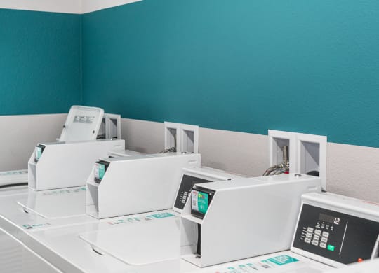 a row of white microwaves in a room with a blue wall