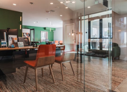 a conference room with glass walls and a table with chairs