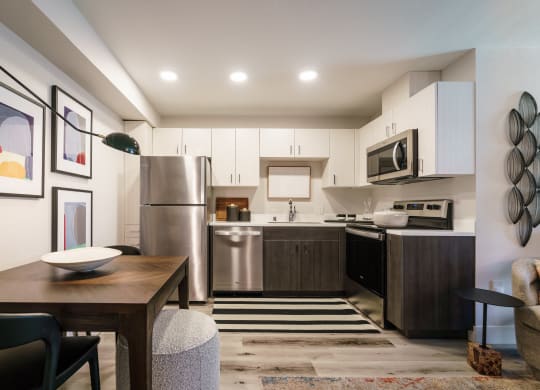 a kitchen with stainless steel appliances and a wooden table