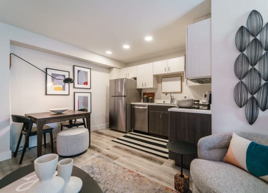 a living room with a couch and a table and a kitchen