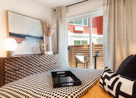 a bedroom with a bed with a black and white comforter and a laptop
