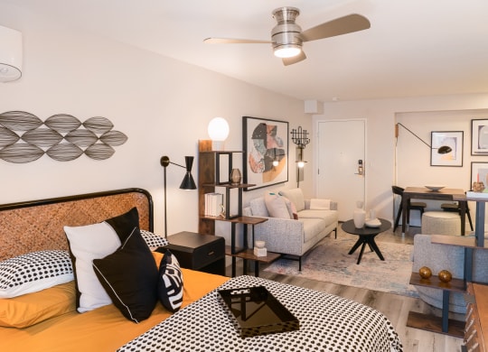 a bedroom with a bed and a living room with a couch