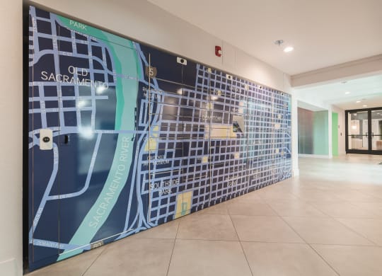 Clubhouse entrance with the community package locker wall painted with a large mural of a Sacramento city map  at Track 281 Apartments, California, 95811