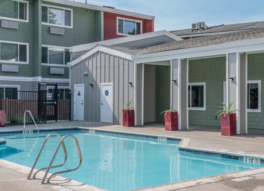 a swimming pool in front of a building with a pool