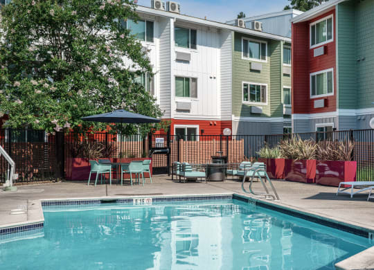 our apartments have a pool and a patio with chairs and tables