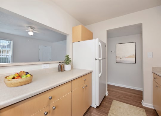 a kitchen with a white refrigerator and a basket of fruit at Vineyard Terrace Apartments, California