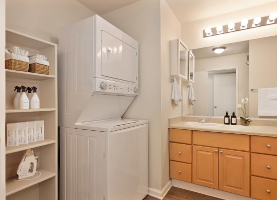 a bathroom with a washer and dryer and a sink and a mirror at Vineyard Terrace Apartments, Napa, 94558