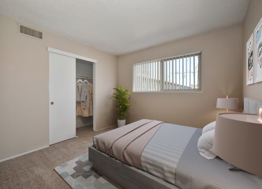 a bedroom with a bed and a closet and a window