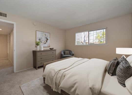 a bedroom with a bed and a dresser and a window