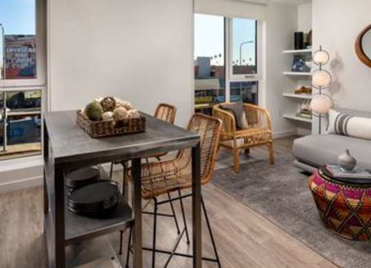A modern living room with a dining table and chairs.