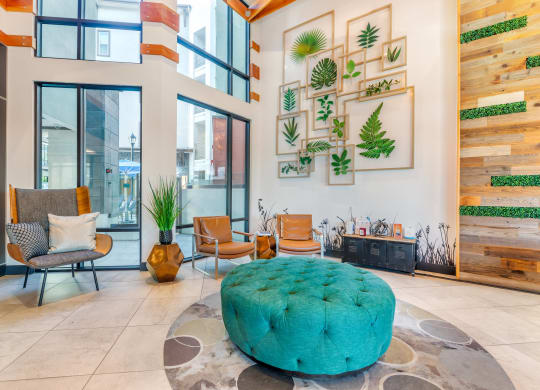 a living room with a turquoise ottoman in the center of it