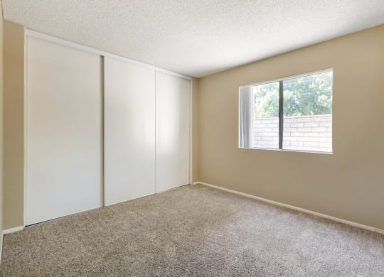 an empty room with white cabinets and a window