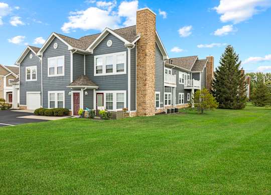 A large house with a grey exterior and a red door.