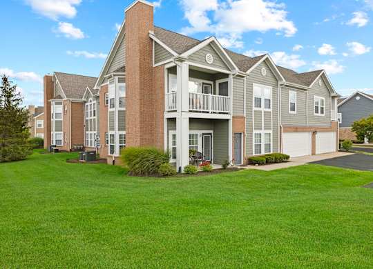 A large apartment complex with a green lawn in front.