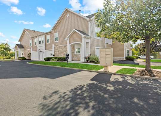 A large house with a driveway in front.