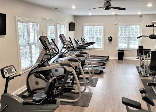 A gym with treadmills and elliptical machines.