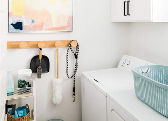 a small laundry room with a washing machine and a painting on the wall at Villas on Ash, Arizona, 85234