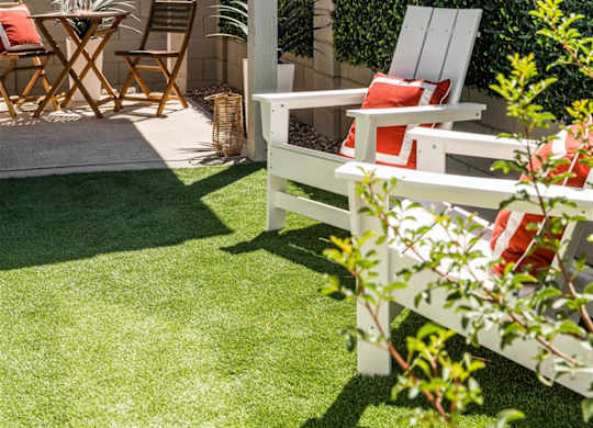 a patio with a table and chairs and a privacy hedge at Villas on Ash, Gilbert Arizona