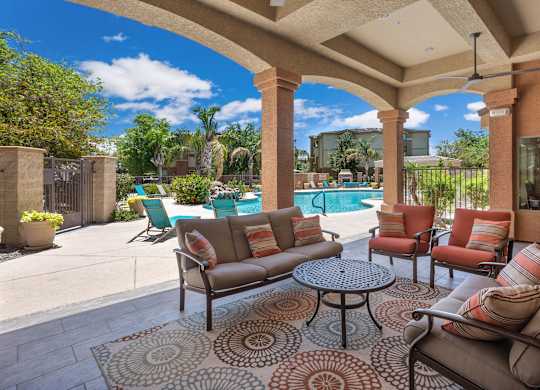 A patio with a couch, chairs, and a table with a rug. at Superstition Canyon Apartments, Arizona, 85209