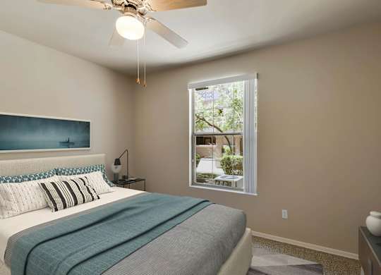 A bedroom with a bed, a ceiling fan, and a window. at Superstition Canyon Apartments, Arizona