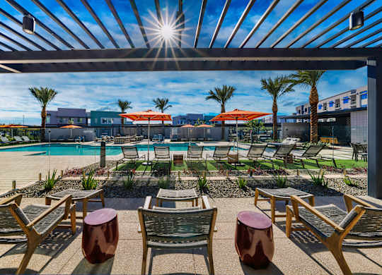 an outdoor patio with tables and chairs and a pool at Elevation at the Village, Gilbert, AZ