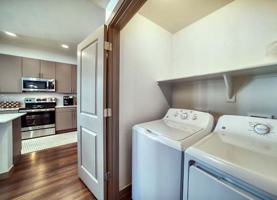 a washer and dryer in a laundry room with a door to a kitchen at Elevation at the Village, Gilbert, AZ