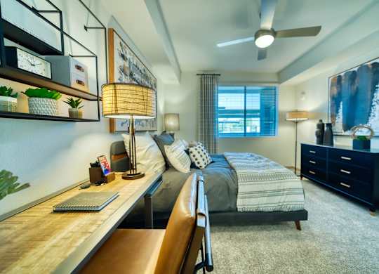 a bedroom with a bed and a desk and a ceiling fan at Elevation at the Village, Gilbert Arizona