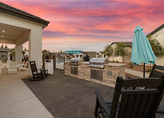 a patio with a grill and a bar with umbrellas at Villas on Ash, Gilbert, AZ
