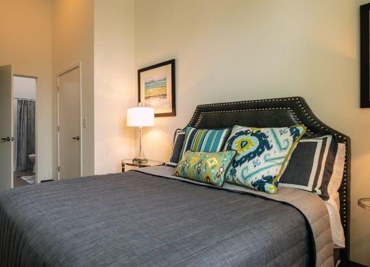 a bedroom with a bed and a door to a bathroom at Link Apartments® Canvas, Atlanta, GA, 30312