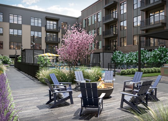 a patio with chairs and a fire pit in front of an apartment building at Link Apartments® Broad Ave, Memphis, Tennessee