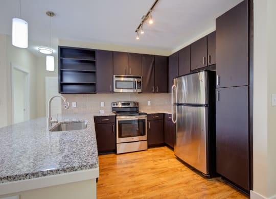 a kitchen with stainless steel appliances and a granite counter top  at Link Apartments® Brookstown, North Carolina