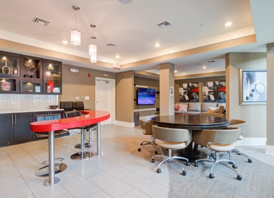 a clubhouse with a red bar and a tv in the back  at Link Apartments® Brookstown, North Carolina