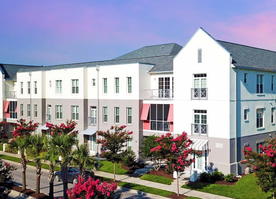 an aerial view of a row of white apartment buildings with red and blue awnings  at Link Apartments® Mixson, North Charleston, 29405