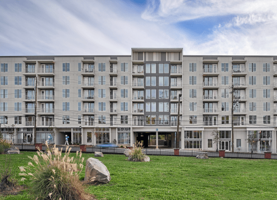 a large apartment building with a grassy area in front of it at Link Apartments® Canvas, Georgia
