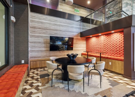 a dining area with a table and chairs and a television at Link Apartments® Broad Ave, Tennessee