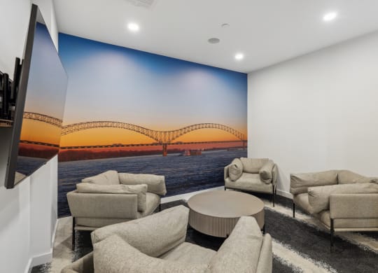 a living room with couches and a wall mural of a bridge at Link Apartments® Broad Ave, Memphis, Tennessee