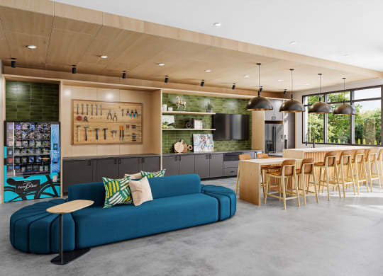 a living room with a blue couch and a kitchen with a table and chairs at Link Apartments® CYKEL Apartments, Charlotte , North Carolina