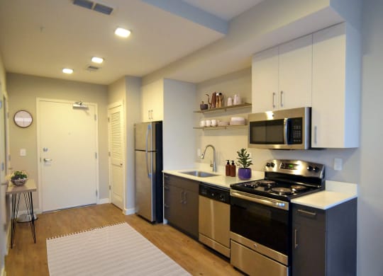 a kitchen with white cabinets and stainless steel appliances at Link Apartments® Canvas, Atlanta