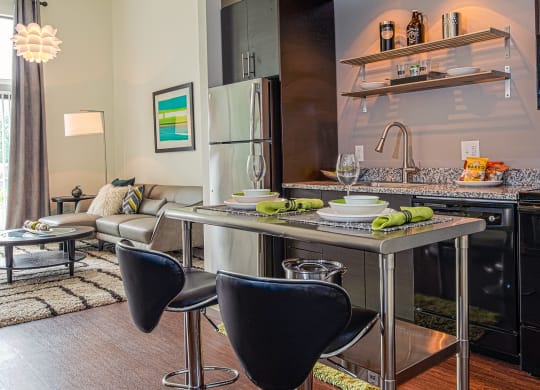 a kitchen with an island and two chairs in front of it at Link Apartments® Canvas, Georgia, 30312