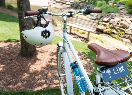 a bike parked in a park with a helmet on the handlebars at Link Apartments® Canvas, Georgia