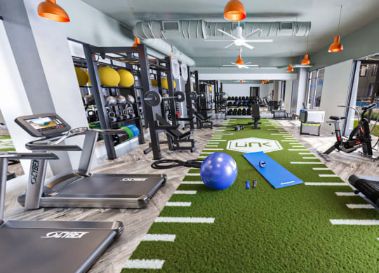 a spacious fitness room with treadmills and other exercise equipment at Link Apartments NoDa 36th, North Carolina