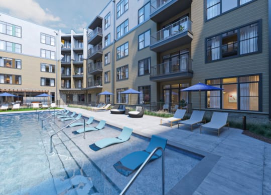 an outdoor pool with lounge chairs and umbrellas in front of an apartment building at Link Apartments NoDa 36th, Charlotte, 28206